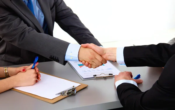 Business meeting at the table shaking hands conclusion of the contract