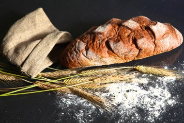 rustik kaşarlı ekmek ve buğday kulaklara koyu ahşap bir masa