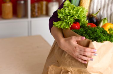 Çeşitli meyve ve sebze kahverengi bakkal çantada bir genç kız