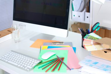 Bilgisayar ve evrak ile tasarımcı çalışma masası