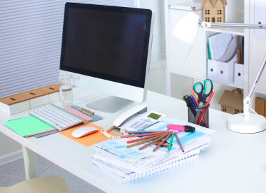 Bilgisayar ve evrak ile tasarımcı çalışma masası