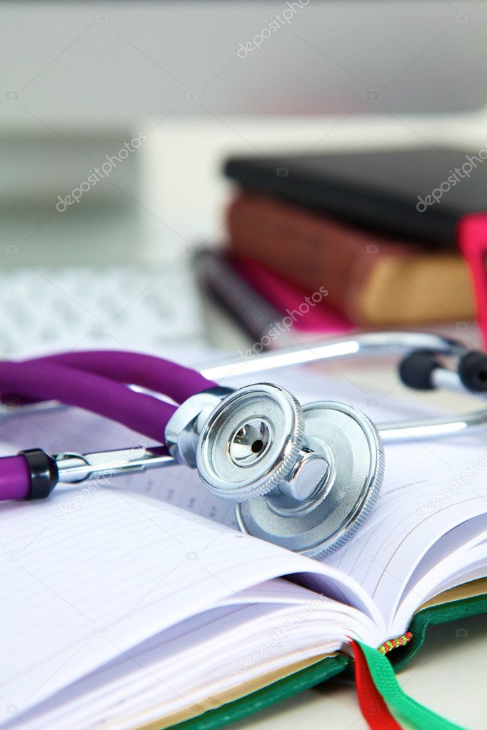 Stethoscope lying on a table an open book