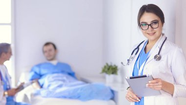 Doktor stetoskop ile yatakta hasta kalp ritmini kontrol