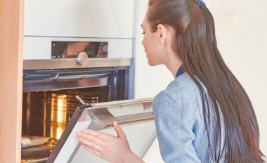 Fırın açık ile bekleyen güzel bir kadın mutfakta