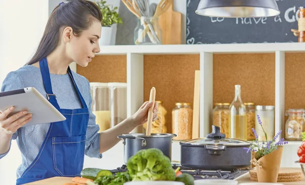 Женщина на кухне, ожидающая у плиты — стоковое фото
