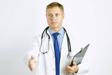 Steteskopla elini uzatan beyaz önlüklü genç doktor.