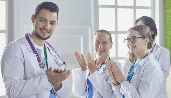 Happy medical team comprising male and female doctors smiling broadly and giving a thumbs up of success and hope — Stock Photo, Image
