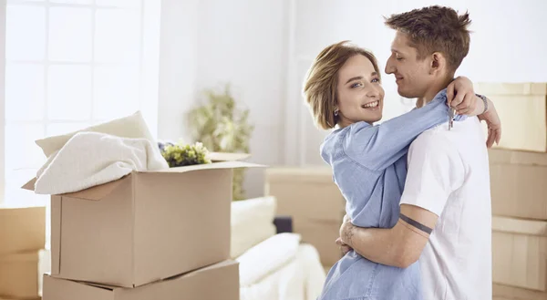 Щаслива усміхнена молода пара показує пару ключів свого нового будинку — стокове фото