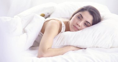 güzel genç kadın yatakta sabah tadını çıkarma. Güzel Model yüz kamera seksi görünüyor