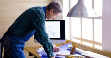 Dizüstü bilgisayarda çalışan ve Proje çizimi mühendis marangoz