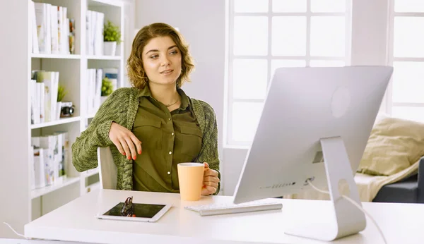 Junge Frau arbeitet im Büro mit Grafik-Tablet lizenzfreie Stockbilder