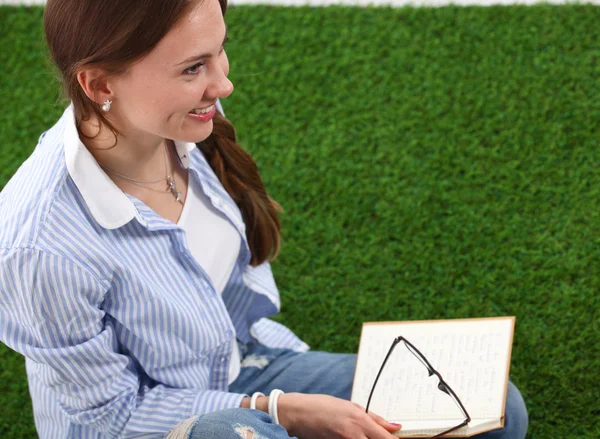 Książka czytanie kobieta siedzi na zielonej trawie — Zdjęcie stockowe
