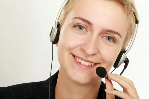 Operadora de centro de llamadas femenino con auriculares navegando en su computadora — Foto de Stock