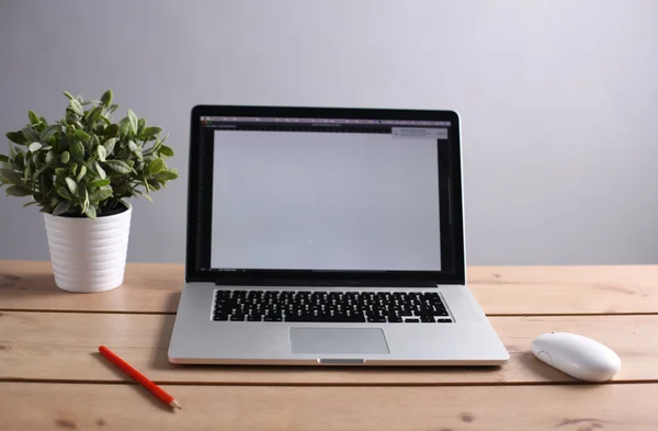 Laptop ahşap bir masada duruyor. — Stok fotoğraf