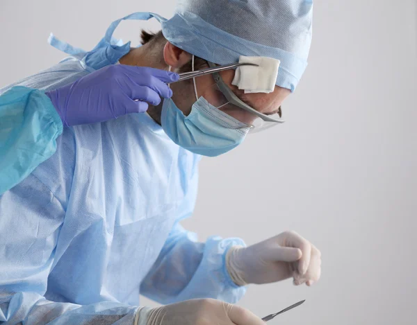 Man chirurg houdt een scalpel in een operatiekamer — Stockfoto