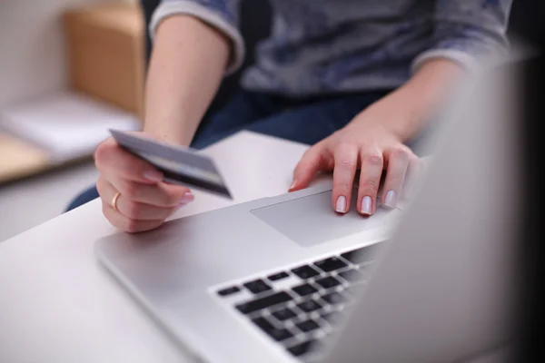 Mujer sentada en el escritorio, comprando con laptop y tarjeta de crédito — Foto de Stock