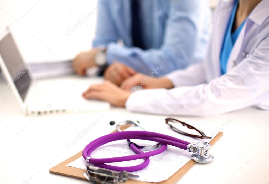 Attractive female doctor shaking a patients hands in her office