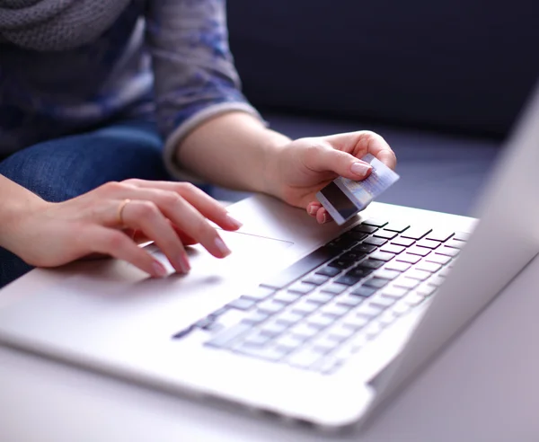 Frau sitzt am Schreibtisch, kauft mit Laptop und Kreditkarte ein — Stockfoto