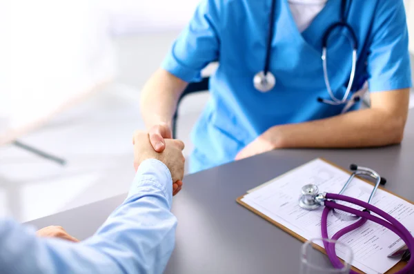 Arzt sitzt am Tisch und schaut Patienten zu — Stockfoto