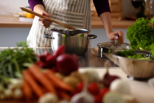 Joven chica está preparando verduras en la cocina — Foto de Stock