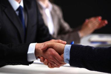 İş adamları iş toplantısında, ofiste oturup tartışıyorlar.