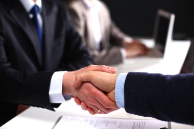 İş adamları iş toplantısında, ofiste oturup tartışıyorlar.