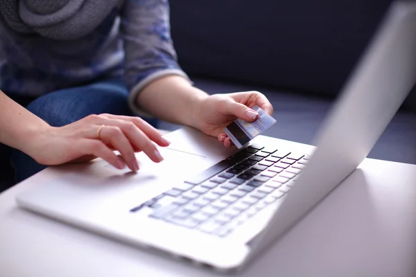 Frau sitzt am Schreibtisch, kauft mit Laptop und Kreditkarte ein — Stockfoto