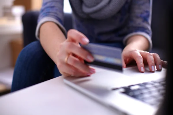 Mujer sentada en el escritorio, comprando con laptop y tarjeta de crédito — Foto de Stock