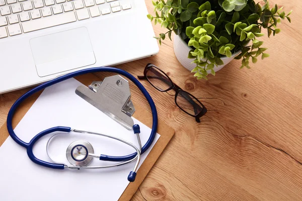 Medical stethoscope lying on a computer keyboard, documents — Stock Photo, Image