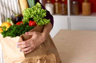 Çeşitli meyve ve sebze kahverengi bakkal çantada bir genç kız
