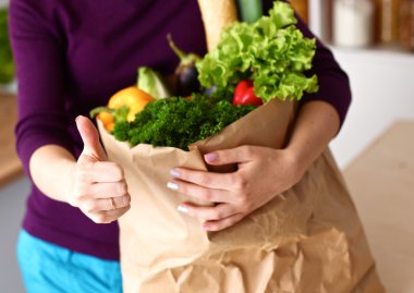 Çeşitli meyve ve sebze kahverengi bakkal çantada bir genç kız