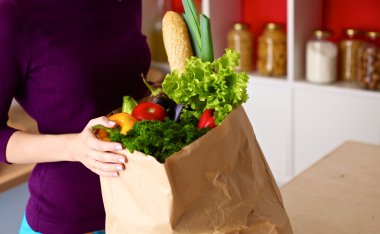 Çeşitli meyve ve sebze kahverengi bakkal çantada bir genç kız