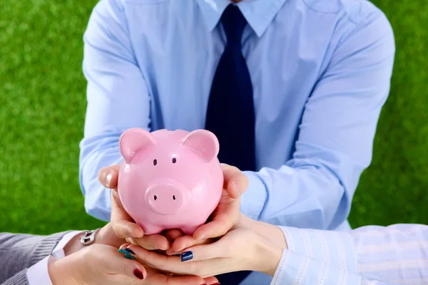 Businessman holding piggy box ,standing in office — Stock Photo, Image