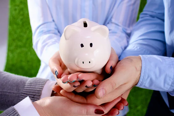 Affärsman holding piggy box, står i office — Stockfoto