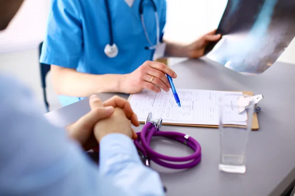 Läkare med stetoskop på patienter erkännanden vid bordet — Stockfoto