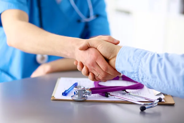 Arzt mit Stethoskop auf der Patientenaufnahme am Tisch — Stockfoto