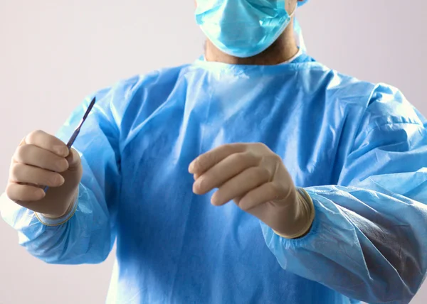 Man kirurg innehar en skalpell i ett operationsrum — Stockfoto