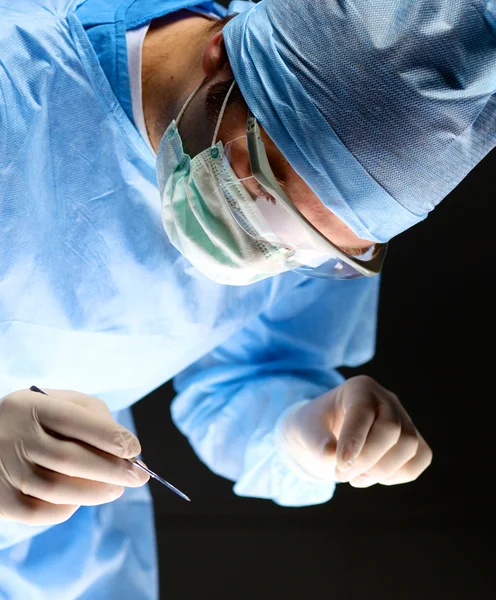 Il chirurgo uomo tiene un bisturi in sala operatoria — Foto Stock
