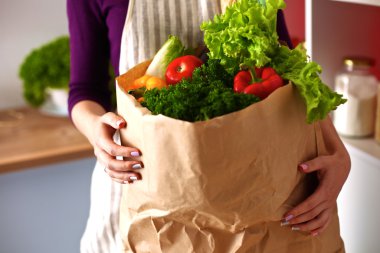 Mutfakta sebze doğrayan genç bir kadın.