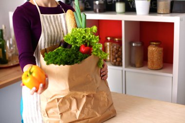 Mutfakta sebze doğrayan genç bir kadın.