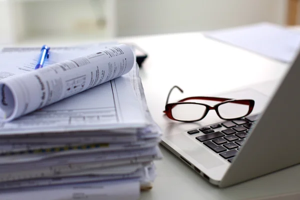 Kağıtları ve gözlük desaturated masanın üzerinde yatan yığını