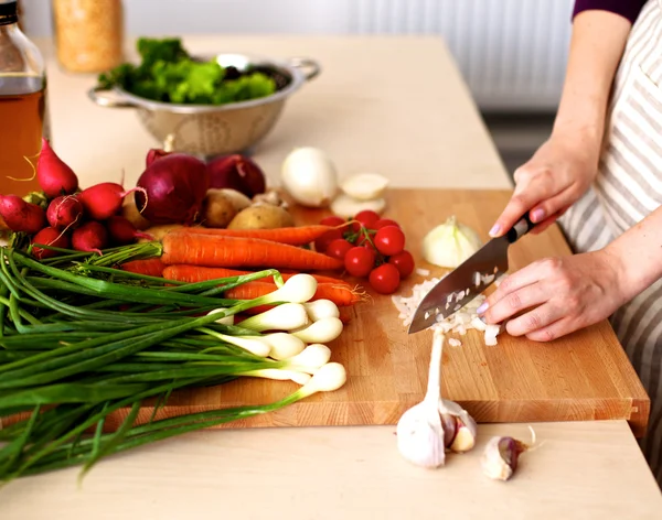 Young woman cutting vegetables in the kitchen — Stock Photo, Image