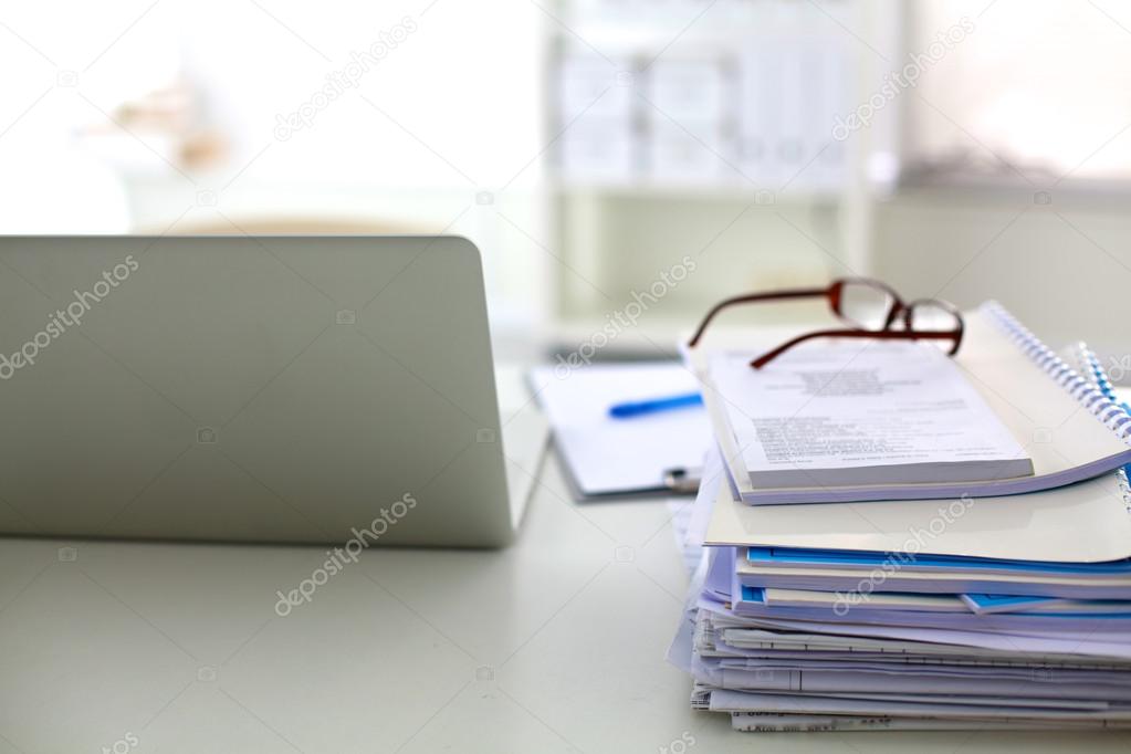 Stack of papers and glasses lying on table desaturated