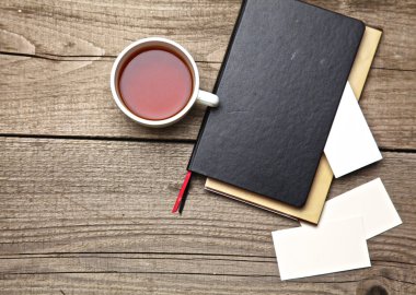 laptop, çay, kartvizit kalem eski ahşap masa ile