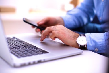 İşadamı bir smartphone ve bir dizüstü bilgisayar ile bir masada