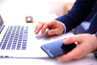 İşadamı bir smartphone ve bir dizüstü bilgisayar ile bir masada