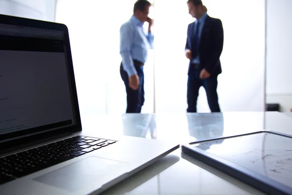 Focus on laptop on the table. Blurred people on background — Stock Photo, Image