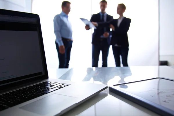 Focus op laptop op de tafel. Wazig mensen op achtergrond — Stockfoto