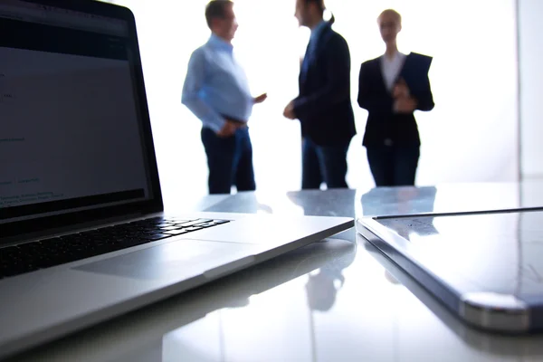 Focus op laptop op de tafel. Wazig mensen op achtergrond — Stockfoto