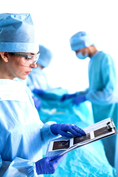 Group of surgeon at work in operating theatre toned in blue — Stock Photo, Image